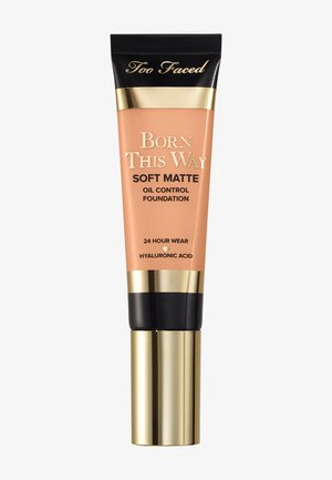 Tube de fond de teint mat doux contrôlant l'huile Too Faced Born This Way avec un bouchon or et noir, tenue 24 heures, et acide hyaluronique.