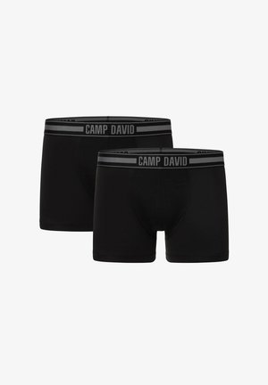 Schwarze Boxershorts aus glattem Stoff, mit einem kontrastierenden grauen elastischen Bund, der das Logo "CAMP DAVID" trägt. Zwei Paare sind abgebildet.