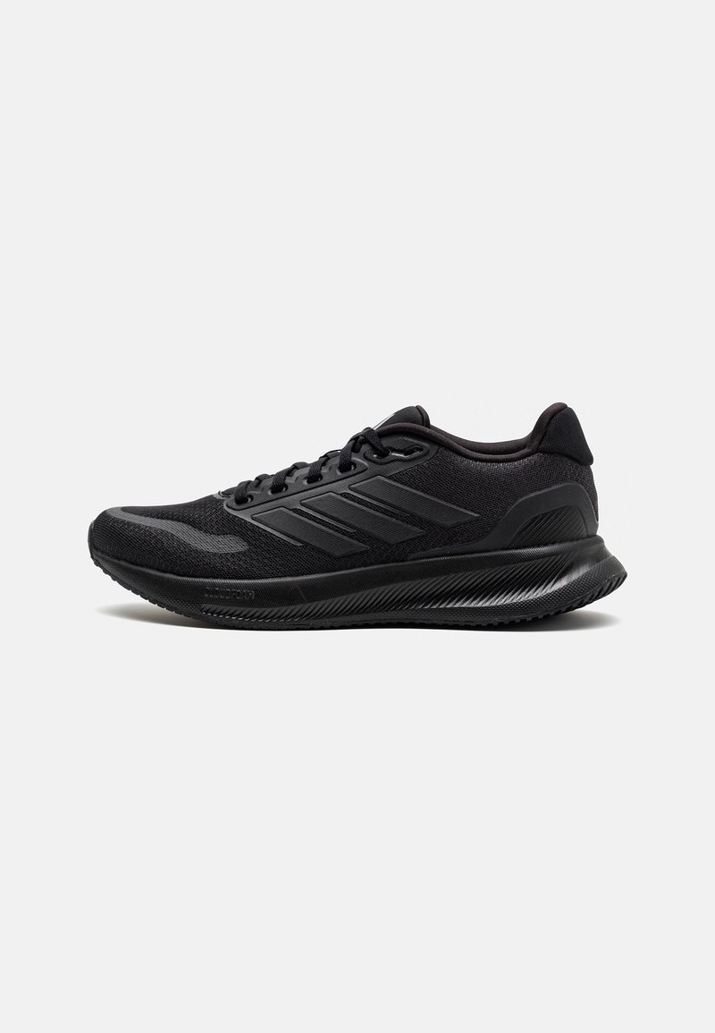 Zapatillas deportivas negras hechas de malla y materiales sintéticos, con una punta redondeada, suela gruesa y un diseño distintivo de tres franjas.