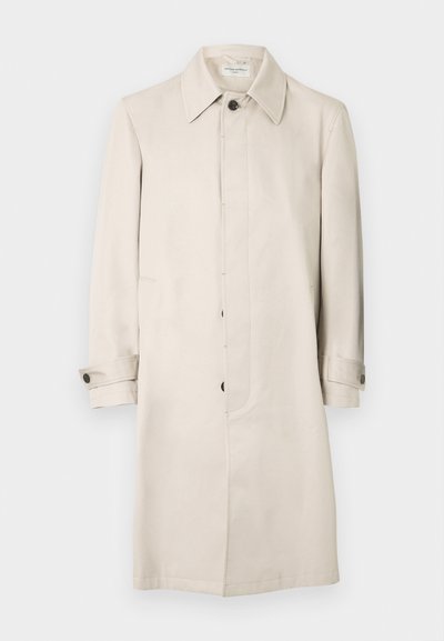 Μπεζ παλτό τύπου trench από λείο ύφασμα, με κλασικό γιακά, κλείσιμο με κουμπιά εμπρός και πλαϊνές τσέπες. Μακριά μανίκια με κουμπωτά μανσέτες.