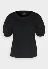 Sort t-shirt med rund hals og korte puffede ærmer lavet af tekstureret, broderet stof. Blødt materiale, afslappet pasform og enkelt design.