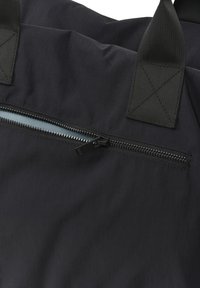 Čierna taška cez rameno s textúrovaným materiálom, ktorá má vodorovnú zipsovú kapsu a pevné čierne rúčky. Minimalistický dizajn a elegantný vzhľad.