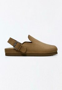 Sabot en daim marron à enfiler avec une bride arrière munie d'une boucle en métal et une semelle en caoutchouc rainurée.