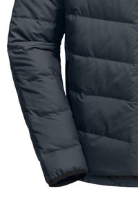 Manica di giacca trapuntata blu scuro. Presenta una texture liscia e opaca con polsini elastici scuri.
