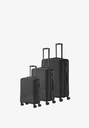 Black hard-shell luggage set of three with ribbed texture, retractable handles, and 360-degree spinner wheels. Varying sizes included.