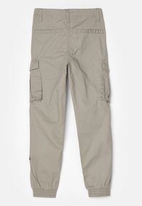 Beige cargo bukser med elastiske manchetter, to sidelommer og to baklommer; laget av lett bomullsstoff med en jevn tekstur.