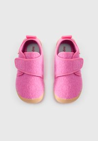 Pink felt shoes with a soft texture, featuring a Velcro strap and a tan rubber sole. The design includes rounded edges and a smooth finish.