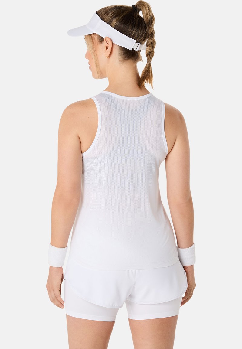 Camiseta deportiva blanca sin mangas con textura de malla y diseño de espalda nadadora, combinada con pantalones cortos blancos y una visera, con acentos minimalistas.