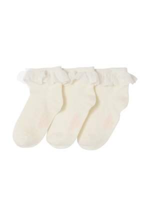 Three cream-colored baby socks with frilly, lace-trimmed cuffs arranged side by side on a white background.