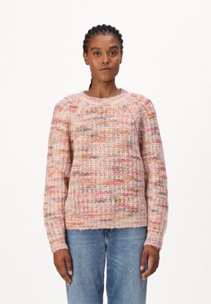 Strickpullover in rosafarbenen Tönen mit mehrfarbigen Sprenkeln, Rundhalsausschnitt, langen Ärmeln und strukturiertem Muster; kombiniert mit hellblauen Jeans.