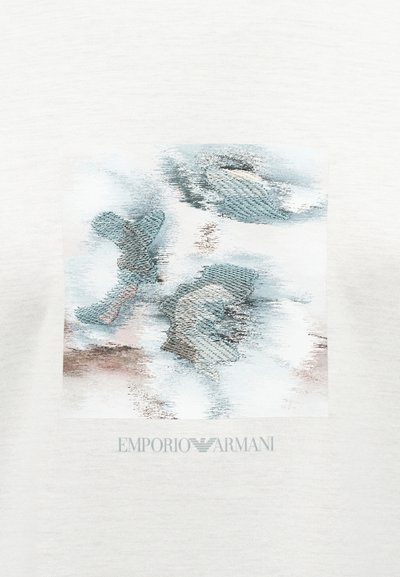 Λευκό βαμβακερό t-shirt με  αφηρημένο κεντητό σχέδιο σε αποχρώσεις του μπλε και του μπεζ, με το κείμενο "EMPORIO ARMANI" κάτω από το γραφικό.