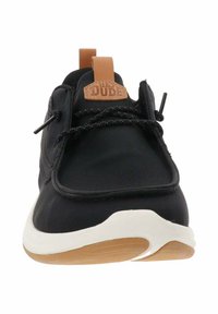 Sneaker nera con una parte superiore sintetica liscia, accento in pelle beige sul tallone e suola in gomma bianca con suola in gomma testurizzata.