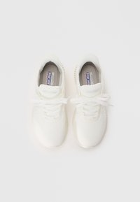 Baskets blanches avec une tige en mesh, des lacets plats et une semelle flexible présentant des détails texturés. Conçues pour un enfilage facile.