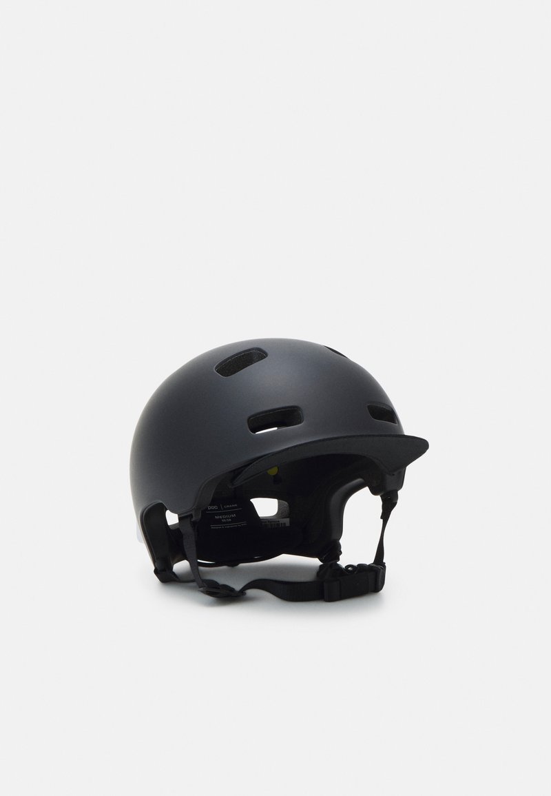 Casco nero con finitura opaca, dotato di fori di ventilazione, cinturino regolabile e un piccolo parasole. L'imbottitura interna garantisce comfort.