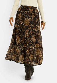 Jupe maxi noire à fleurs avec trois volants, ornée de motifs floraux verts et bordeaux. Fabriquée dans un tissu léger et fluide.