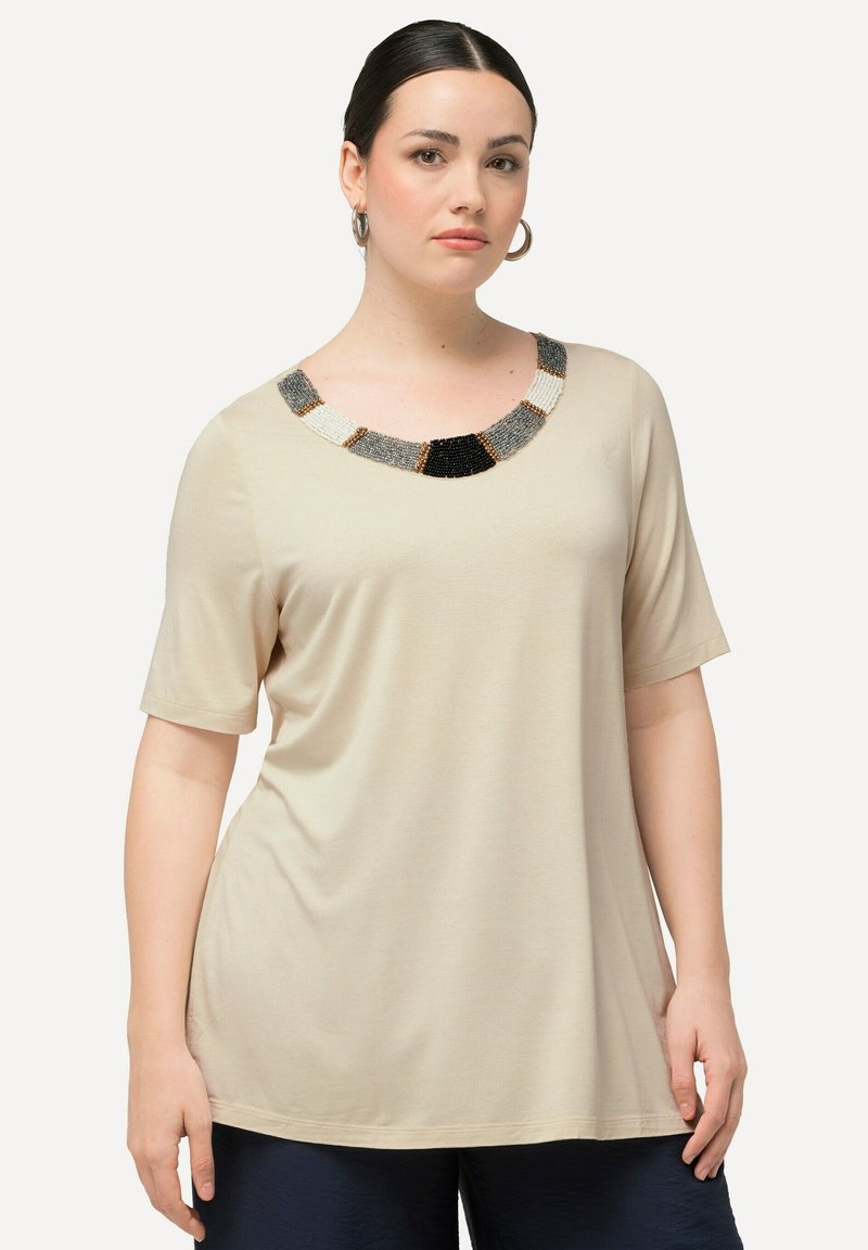 Beige Kurzarmtop mit einem runden Ausschnitt und einem dekorativen, mit Perlen besetzten Kragen in Schwarz, Grau und Weiß. Weicher Stoff, lockere Passform.