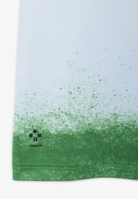 Ljusblått tyg med ett grönt gradientmönster, med strukturerad detaljering vid fållen och svart "DANILM"-logotyp längst ner.