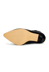 Chaussure en cuir noir avec un bout pointu, présentant une finition lisse et une semelle en caoutchouc de couleur claire. Inclut un accent décoratif sur le côté.