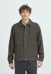 Grå uldblandingsjakke med krave, frontlukning med knapper, to store lommer og et subtilt tekstureret mønster. Casual pasform med lange ærmer.