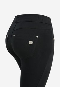 Jeans neri elasticizzati con cinque tasche, caratterizzati da dettagli in metallo argentato e un design aderente. Texture liscia con cuciture decorative.