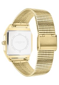 Orologio in acciaio inossidabile dorato con quadrante quadrato e bracciale a rete. Presenta una parte posteriore trasparente e una chiusura a fibbia, con una finitura dettagliata sul bracciale.
