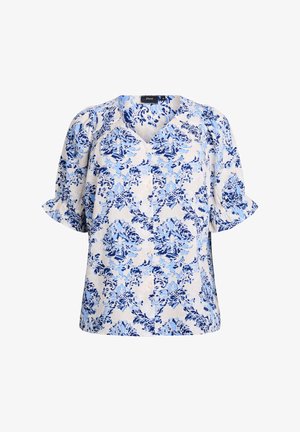 Blouse à manches courtes en tissu léger avec un motif floral bleu complexe sur un fond crème. Design en V avec des boutons.