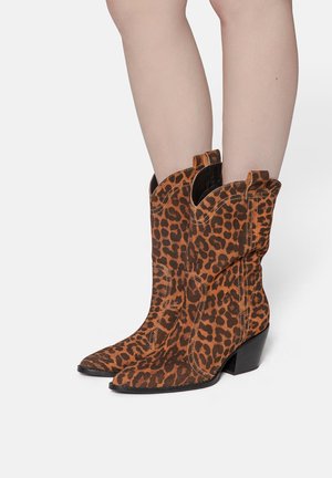 Bottes de cowboy en cuir suédé avec un imprimé léopard, présentant un bout pointu, un talon noir et des coutures décoratives le long des coutures.