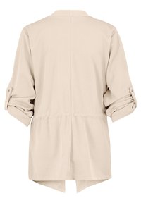 Veste beige à manches longues avec manches retroussées fixées par des pattes boutonnées, dotée d'une taille cintrée et d'une fente à l'arrière.