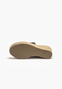 Czarne klapki na koturnie z plecioną platformą z juty. Gładka cholewka, okrągły nosek i solidna gumowa podeszwa. Rozmiar oznaczony jako 37 na spodzie.