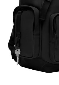Sac à dos noir en tissu durable, avec plusieurs poches zippées extérieures, des bretelles ajustables et un porte-clés avec une clé.