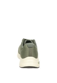 Zapatilla deportiva verde con parte superior de malla texturizada, cuello acolchado y una entresuela blanca. Presenta una suela exterior de goma negra flexible.