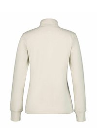 Cream-colored long-sleeve fleece jacket with high collar, visible seams, and small logo centered on upper back.