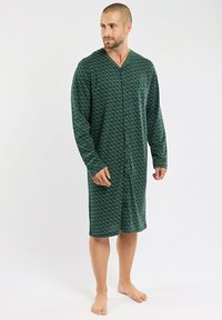 Chemise de nuit à motifs verts avec des manches longues, dotée d'un décolleté en V et d'une fermeture à boutons. Fabriquée en tissu doux, elle est de longueur genou et présente un design subtil.