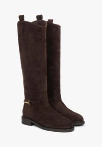 Knee-high bruine suède laarzen met een gladde textuur, platte zool en decoratieve zijhardware. Voorzien van trekbands aan de bovenkant.