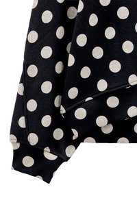 Czarna bluza z dużymi białymi kropkami. Posiada prążkowane mankiety i dół, miękką teksturę oraz casualowy design.