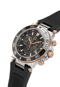 Chronograafhorloge met een zwarte wijzerplaat, zilveren en roségouden roestvrijstalen kast, zwarte rubberen band en gedetailleerde subdials voor tijdregistratie.