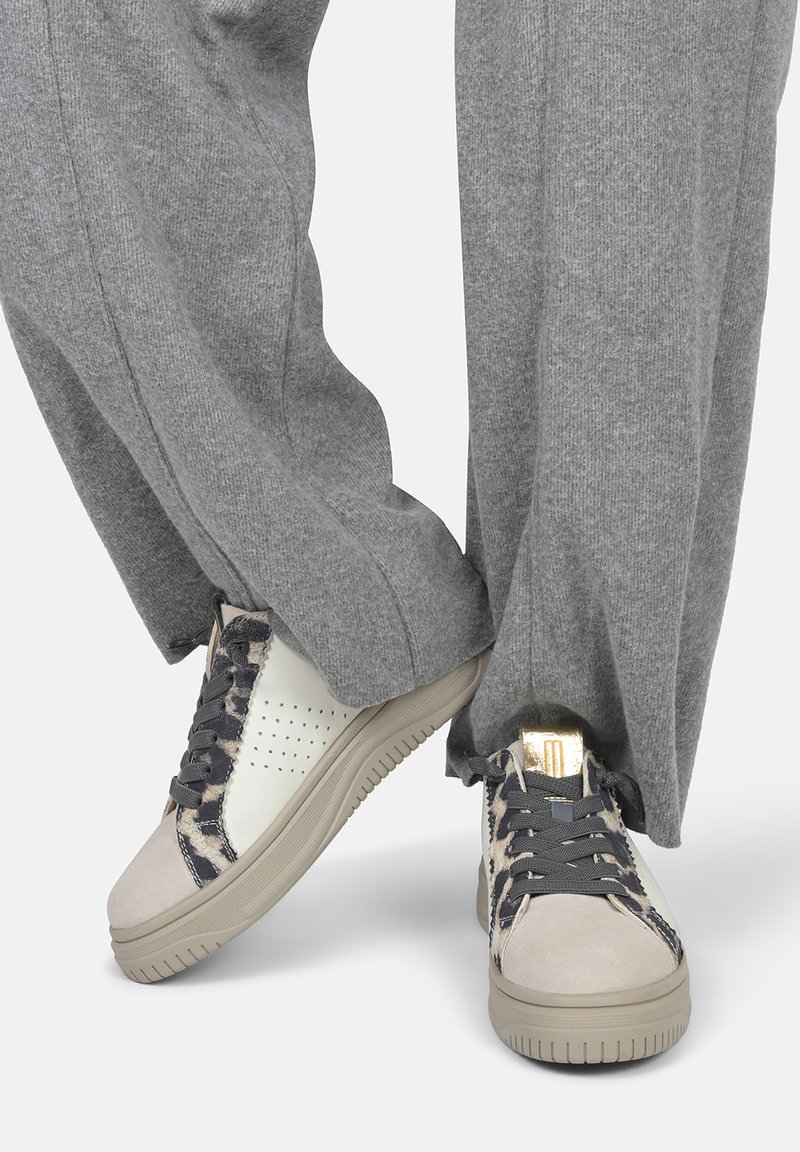 Sneakers met een mix van witte leer en grijze suede, afgewerkt met donkergrijze veters, een gouden accent op de hak en gestructureerde patronen.