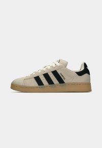 White suede sneaker with three black stripes, cream laces, and a gum sole. Features a padded tongue and heel, branded with "CAMPUS."