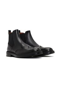 Botas Chelsea de cuero negro con detalles de brogue, paneles laterales elásticos, lengüetas y punta redonda. Acabado suave y con un tacón bajo apilado.