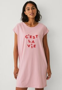 Lyserød bomulds t-shirt kjole med korte ærmer og rund halsudskæring. Har rød trykt tekst "C'est la vie" i forskellige størrelser. Blød tekstur.