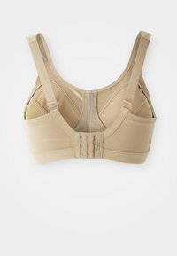 Sostén beige con tirantes ajustables, copas sin costuras y cierre de gancho en la parte posterior. Tejido suave con una textura lisa.