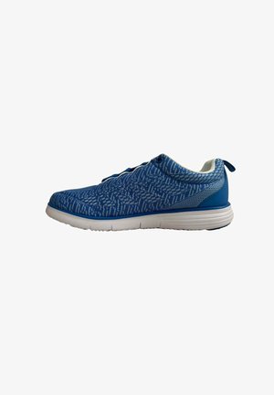 Zapatilla deportiva azul con patrón de punto blanco y gris claro, suela blanca acolchada y tira de agarre en el talón, vista de lado.