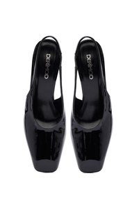 Zapatos de mujer slingback negros brillantes con punta cuadrada, exhibidos uno al lado del otro, con el nombre de la marca visible en el interior.