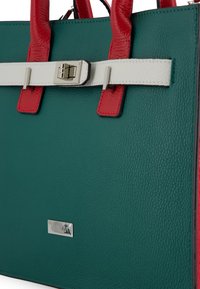 Groene gestructureerde leren handtas met rode handvatten, witte schouderband, zilveren gesp en klein rechthoekig zilveren Venezia logo plaatje.