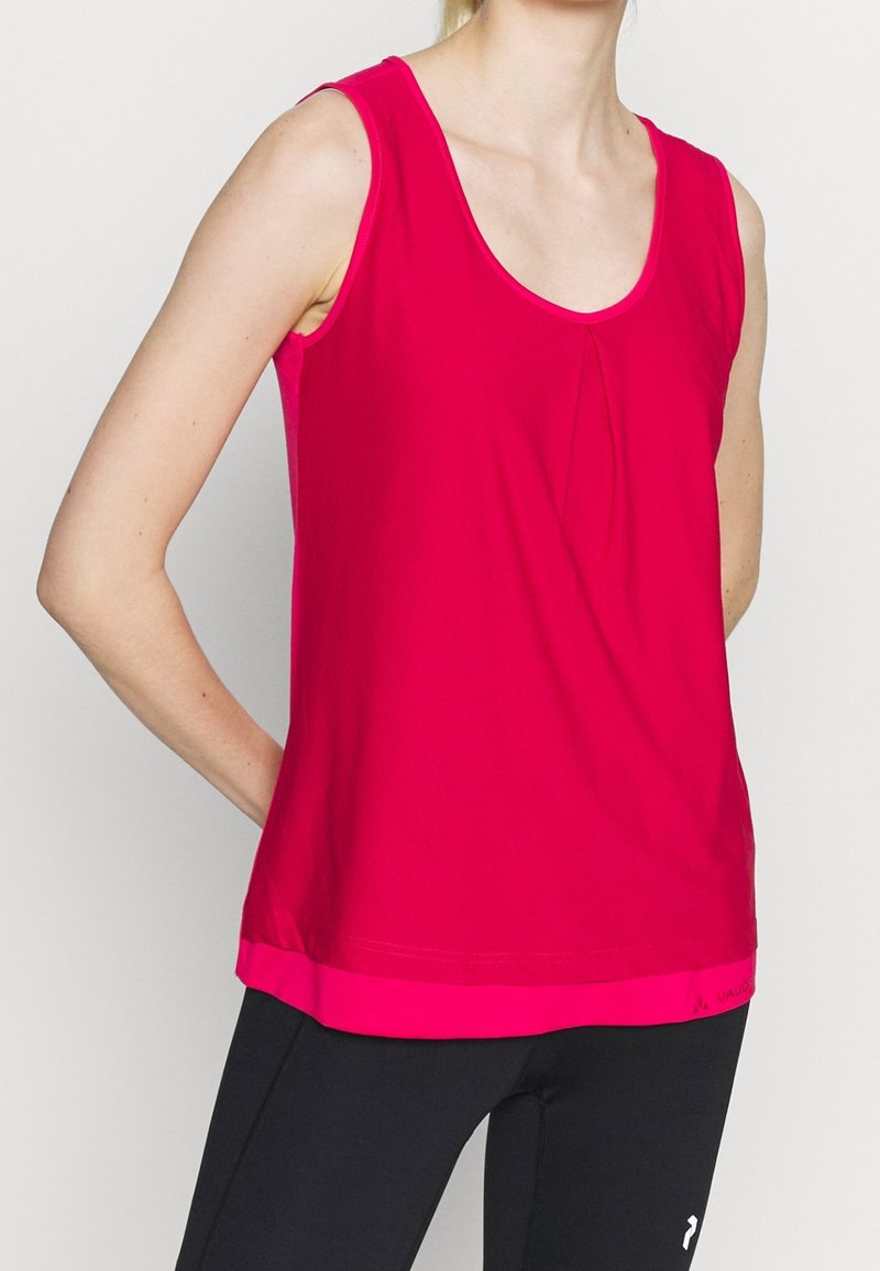 Fuchsiový bezrukávový top s kulatým výstřihem, zdobený jemným nařasením a kontrastním lemováním. Tkanina vypadá hladce a lehce.