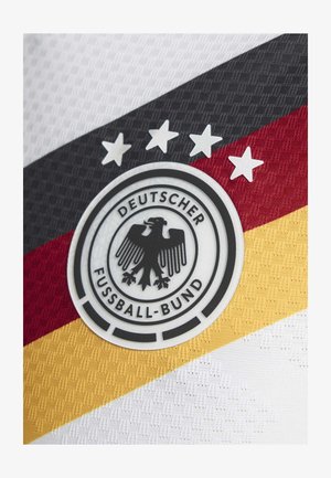 Hvid og sort tekstureret stof har logoet fra det tyske fodboldforbund, med en sort ørn og fem stjerner over røde og gule striber.