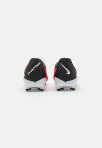 Botas de fútbol negras y rojas con una parte superior suave, detalles en blanco y una suela texturizada con seis tacos para tracción. Área del talón acolchada.