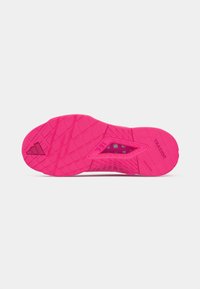 Pink shoe sole featuring a textured pattern with a triangular cutout and "TRAXION" branding. Textured grip surface for traction.