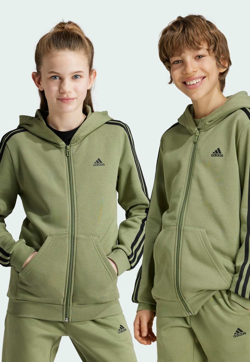 Sudaderas verdes con cremallera y capucha, hechas de una tela suave, con franjas laterales negras y bolsillos frontales. Logo de Adidas exhibido de forma prominente en el pecho.