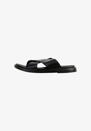 Sort læder slip-on sandal med brede krydsede remme og flad sål, vist i venstre sideprofil på hvid baggrund.